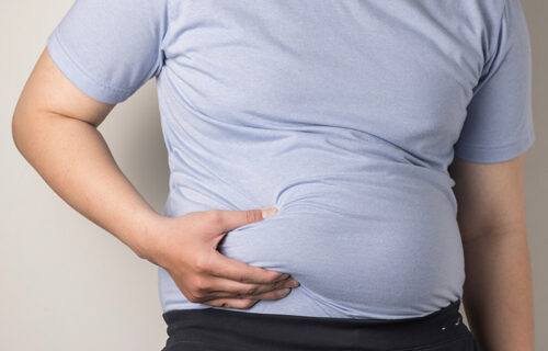 overweight or obese man shows fat deposits in the abdomen. healt