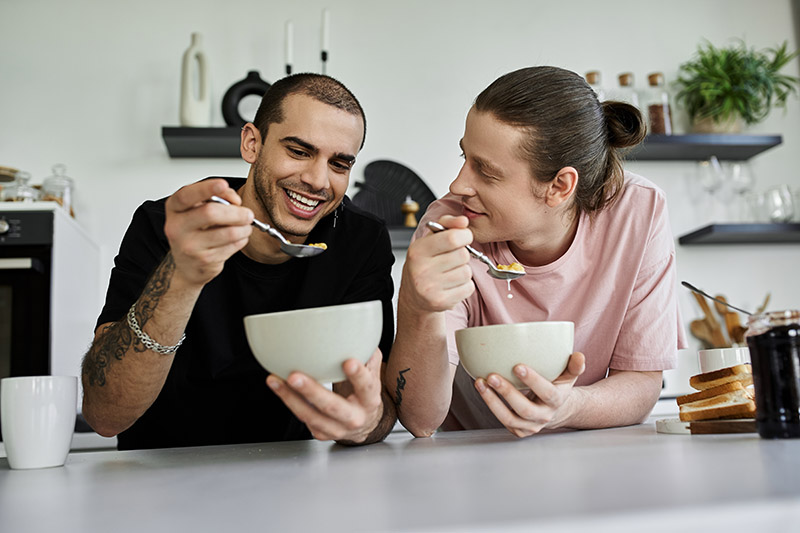 A young gay couple enjoys a leisurely breakfast together in thei