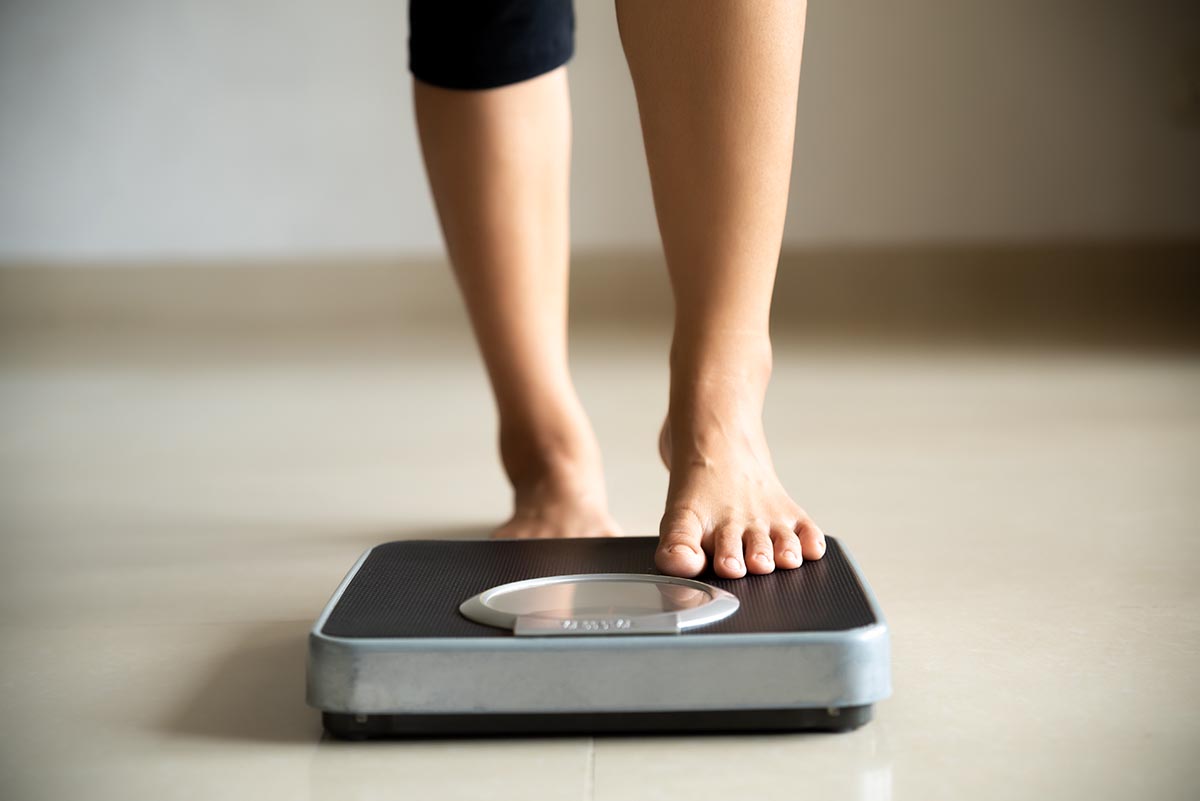Female leg stepping on weigh scales. Healthy lifestyle, food and